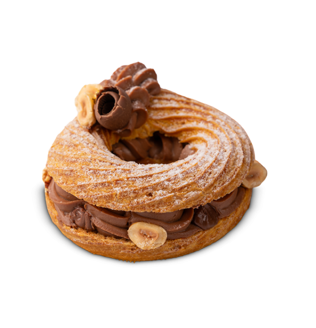 Prstenasti kolačić Paris-Brest punjen kremom od čokolade i lješnjaka, ukrašen kovrčicom čokolade i cijelim lješnjacima.