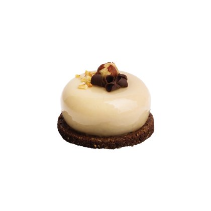 Okrugla mini torta sa sjajnom karamel glazurom na čokoladnoj keks podlozi, s mljevenim orasima i cijelim lješnjakom