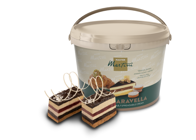 Velika kanta namaza Master Martini "Aravella" pored dvije kriške slojevite torte s čokoladnim strugotinama.