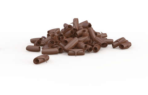 Uvijene čokoladne strugotine razbacane na bijeloj pozadini